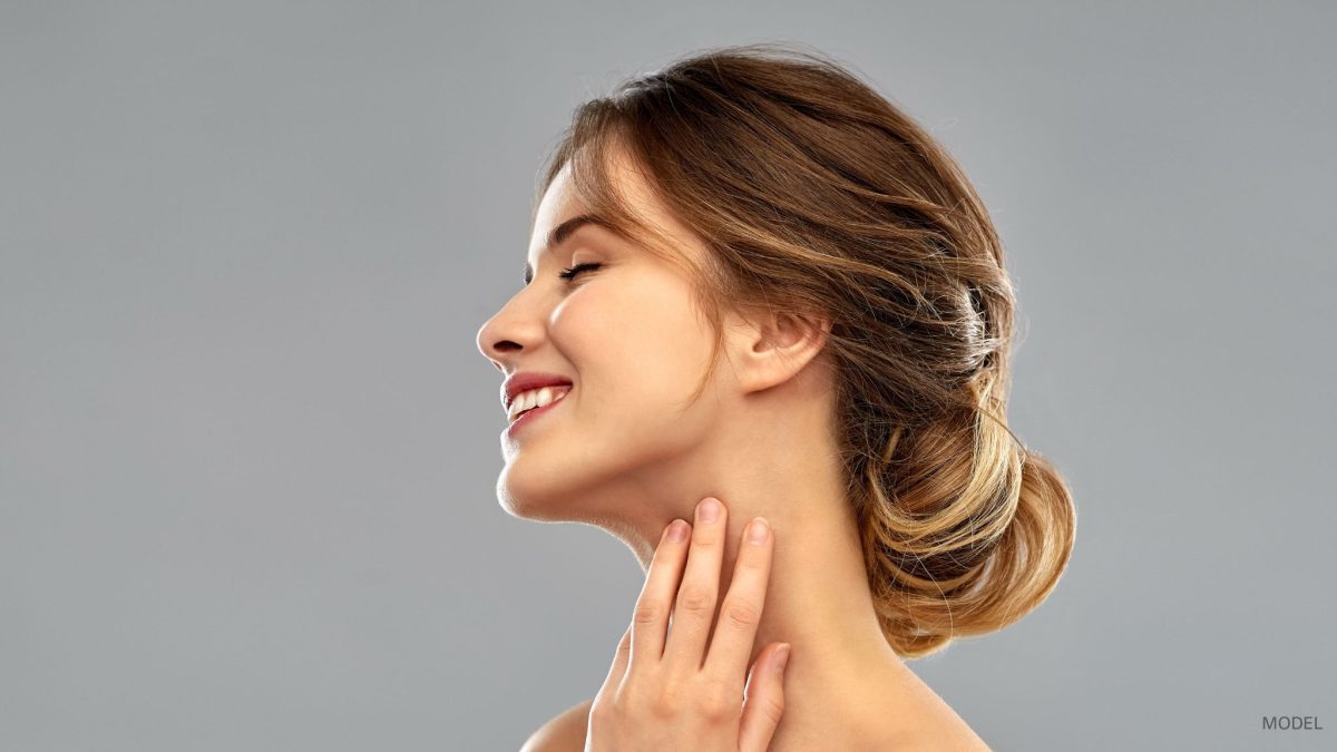 A woman with a beautiful nose, shows off her profile while smiling. (Model)